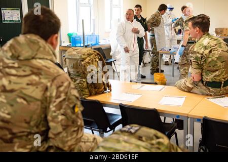 Members of the British Army learn how to apply PPE during training to support the Welsh Ambulance Service NHS Trust (WAST) in the battle against COVID-19 at the Sennybridge Training Camp in Mid Wales. Stock Photo