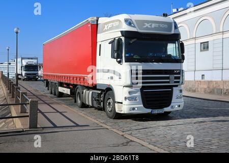 White DAF XF 105.460 semi trailer driving on cobbled Helsinki street after arrival in Port of Helsinki, Finland on sunny day of spring. April 7, 2020. Stock Photo