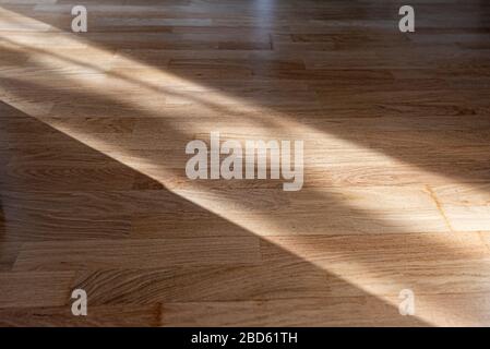 Sun ray or beam on wooden floor, sunlight lines shadow on parquet, interior with sunlight Stock Photo