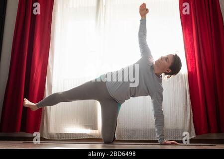 Peaceful sporty woman practicing yoga side plank or vasishtasana Stock Photo