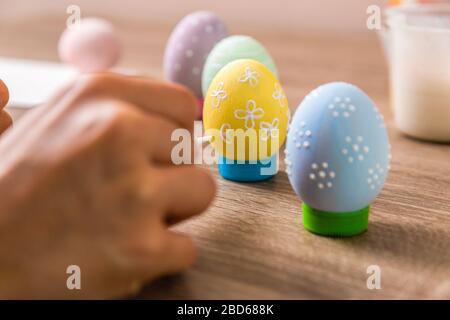 easter tradition. closeup child hands painting eggs in different colors on wooden table Stock Photo