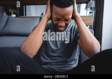 stressed african american man having healthcare while suffering from panic attack at home Stock Photo