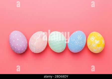 multicolor hand painted eggs and decorated at home over pink background. easter tradition Stock Photo