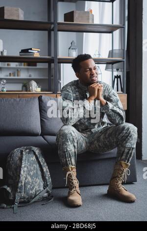 sad african american soldier in military uniform suffering from PTSD at home Stock Photo