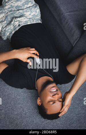 stressed african american soldier with army badge having panic attack at home, suffering from PTSD Stock Photo