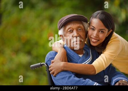 Portrait of elderly man in a wheelchair with his daughter. Stock Photo