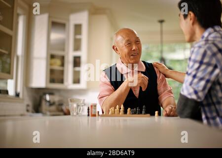 Father and son playing a game of chess. Stock Photo