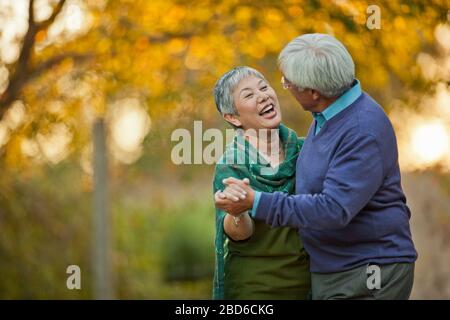 Happy senior couple playfully dancing together. Stock Photo