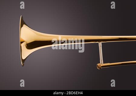 Part of the bell of a trombone with gray gradient background. Side view. Horizontal composition. Stock Photo