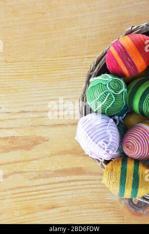 Eggs decorated with threads on wooden  table Stock Photo