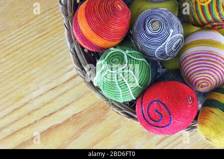 Basket with eggs decorated with threads on wooden  table Stock Photo