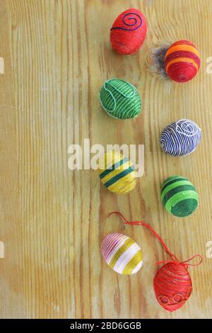 Eggs decorated with threads on  rustic wooden  table Stock Photo
