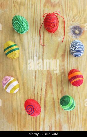 Eggs decorated with threads on  rustic wooden  table Stock Photo