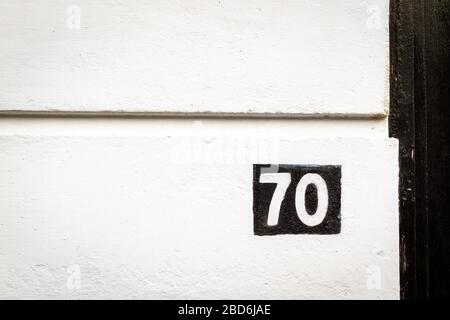 House number 70 painted inversely on a house wall Stock Photo