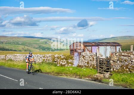 Cyclist climbing Buttertubs Pass. Yorkshire Dales National Park. UK. Stock Photo