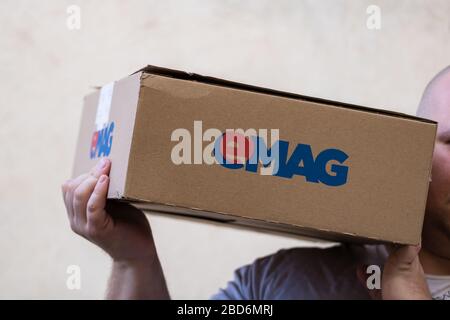 Deliveryman holding eMAG cardboard box isolated on blurred background in Bucharest, Romania, 2020 Stock Photo