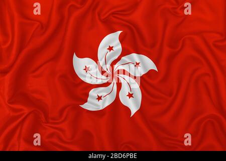 Hong Kong flag on wavy silk textile fabric background. Stock Photo