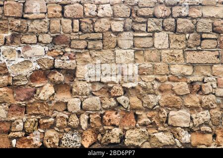 Texture of the ancient dilapidated wall fencing in the old town Stock Photo