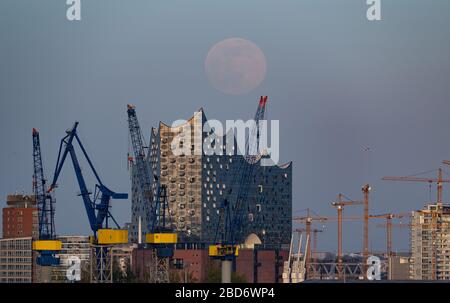 Hamburg, Germany. 07th Apr, 2020. The moon rises as a so-called supermoon, in the foreground the Elbphilharmonie can be seen. The moon reaches its perigee, i.e. the point closest to the Earth's orbit, as a full moon in the night of April 7-8 and therefore appears particularly large to the human observer. Credit: Daniel Reinhardt/dpa/Alamy Live News Stock Photo