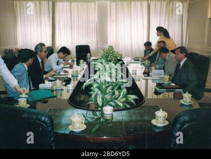 CHINA - 1989: Retro photo shows a group of caucasian - European businessmen and Chinese businessmen have a working meeting. Stock Photo