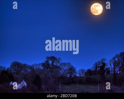 full pink supermoon rising over Wirksworth Derbyshire UK SafeMoon Stock Photo