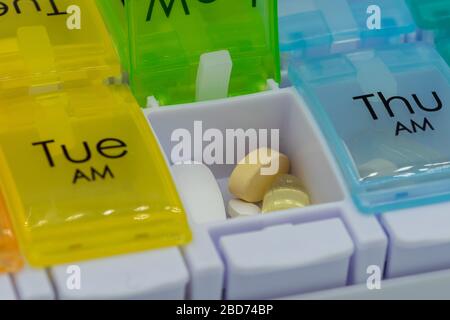 A close up of pills inside a pill box or medication box used for counting out medication for the week Stock Photo