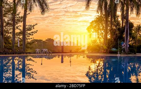 Sun setting over a resort swimming pool Stock Photo