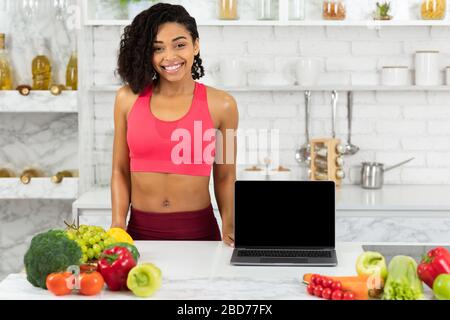 Black girl showing laptop with blank screen Stock Photo