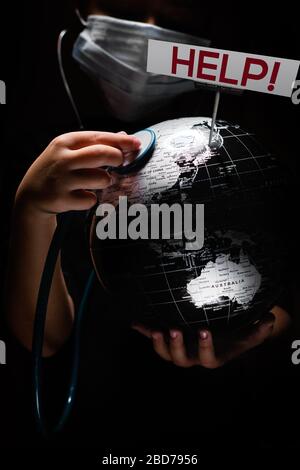Kid hold globe put stethoscope on sphere where shown billboard Help red letters face covered in mask on black background. Pandemic outbreak Covid 19, Stock Photo
