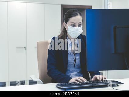 businessman working on laptop in office with the surgical mask Stock Photo
