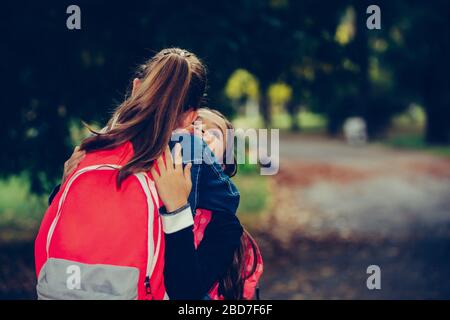 Two school friends hugging, meet in the park. Walking into each other with open arms and smiling. The concept of school, study, education, friendship, Stock Photo