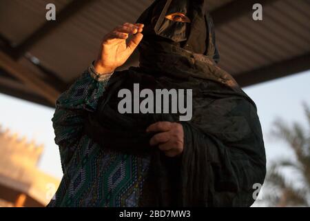 Omani women wearing a Batoola haggle for livestock at the friday market ...