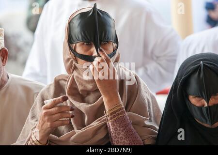 Omani women wearing a Batoola haggle for livestock at the friday market ...
