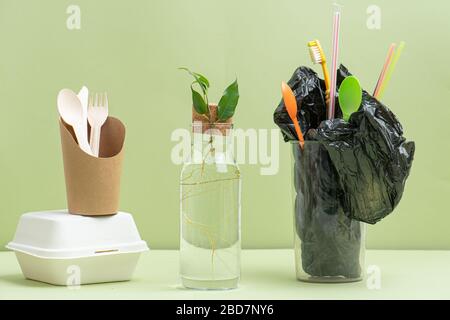 Eco-friendly utencils, branch in a bottle and plastic bag in glass Stock Photo