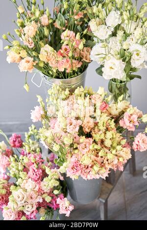 Bunches of flowers different varieties eustoma in vases. Lovely Vintage background with flowers. Wallpapers Stock Photo
