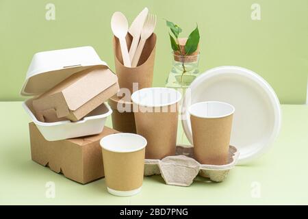 Eco-friendly containers made from various materials over green Stock Photo