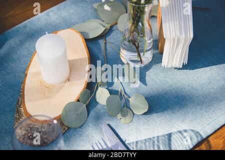 Festive table setting on a background of blue napkins. Tree branch. Stock Photo