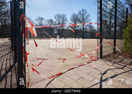 Empty playground without kids, off bound to children and parents. Closed off with striped red white barrier tape. Restrictions, quarantine for disease Stock Photo