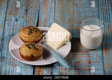 Corn bread made in the form of muffins ( proja ) with sesame and pumpkin seeds with cheese and glass of yogurt. Balkan cuisine. Blue rustic wood Stock Photo