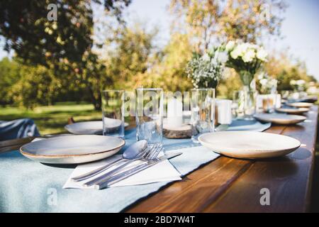Festive table setting on a background of blue napkins. Tree branch. Stock Photo