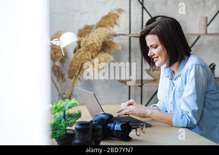 Working from home. Communication online. Portrait of smiling female freelancer using laptop Stock Photo