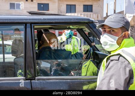 Baalbek, Lebanon, 7 April 2020. Civil Defence staff run a fever check on all people in vehicles in an effort to contain novel coronavirus and prevent spread to vulnerable areas. Temperatures of 38.5 celcius or more are taken to the closest hospital for testing. Elizabeth Fitt Credit: Elizabeth Fitt/Alamy Live News Stock Photo