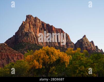 The last rays of the autumn sun illuminate a beautiful red rock mountain in Zion National Park. Stock Photo