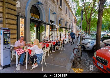 Rome streets, alfresco dining, people eating on outside tables on the sidewalk at Ottavio Pizza e Spaghetti pizzeria in Rome, Italy. Stock Photo