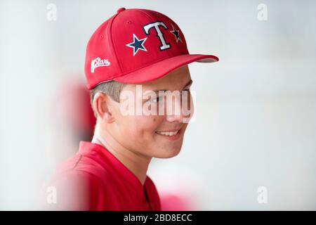 Close-up portrait of teen baseball player in red cap and uniform Stock Photo