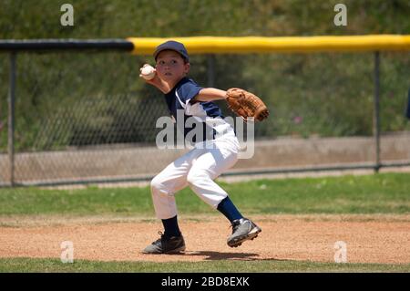 Little League baseball infielder ready to throw to first base Stock Photo