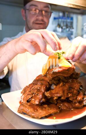 chef putting finishing touch to his dish before serving it Stock Photo