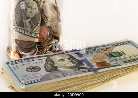 Glass jar and pile of money isolated on a white background. Stock Photo