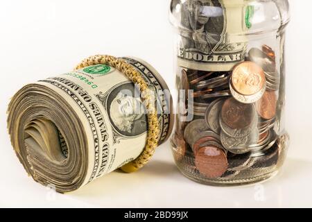 Glass jar and roll of money isolated on a white background. Stock Photo