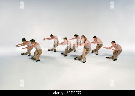 Modern Dancers (model released) perform on white seamless stage. Stock Photo